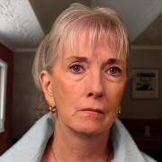 Middle-aged woman with light hair and a sad expression